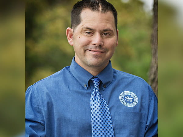 A headshot of Craig Northcutt smiling in an outdoor setting.