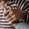 caregiver holding a senior woman's hand to provide support