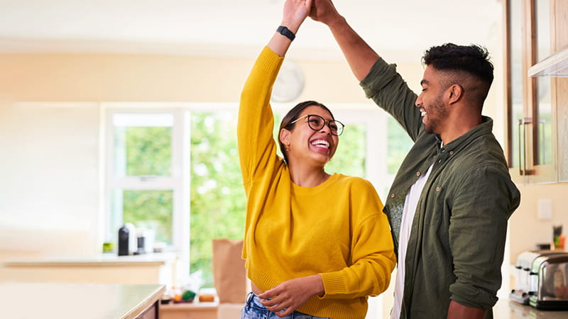 A young couple dancing together in their kitchen