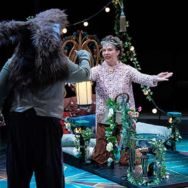 Maggie Whittum is on stage acting out a scene in a play. Maggie Whittum is on stage acting out a scene in a play.