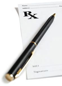 a black pen is laying on top of a white prescription pad