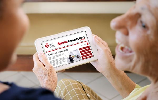 senior woman smiling and reading Stroke Connection on a tablet