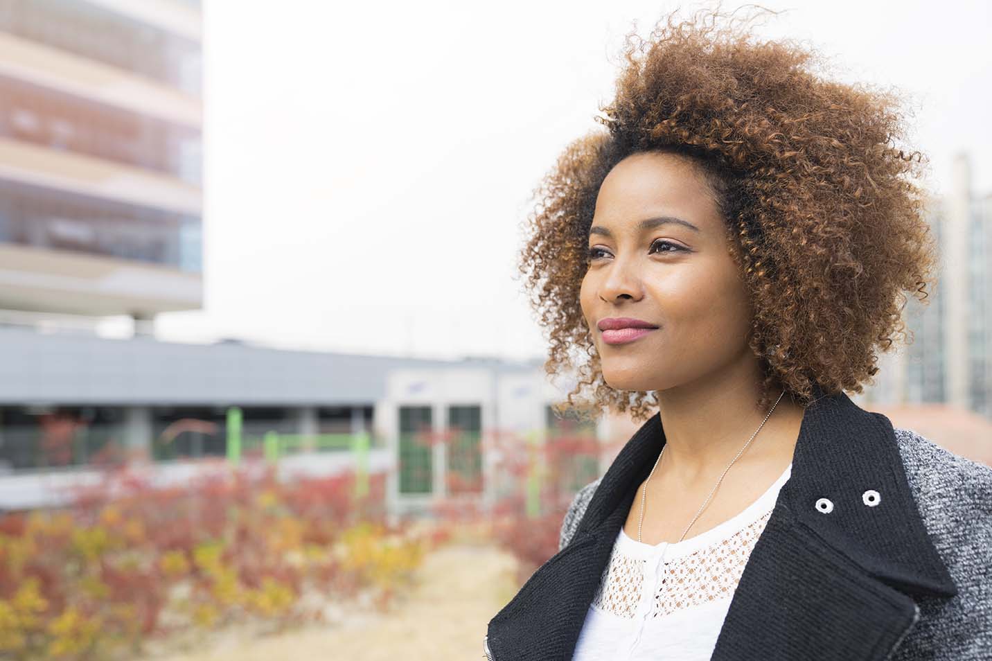 Woman standing by a building on the road