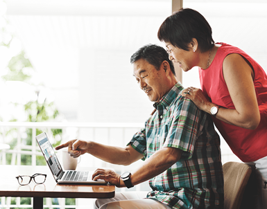 Senior couple at home on computer